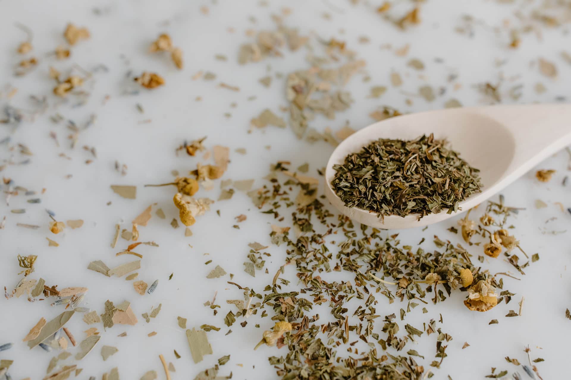 A measuring spoon holding loose leaf tea