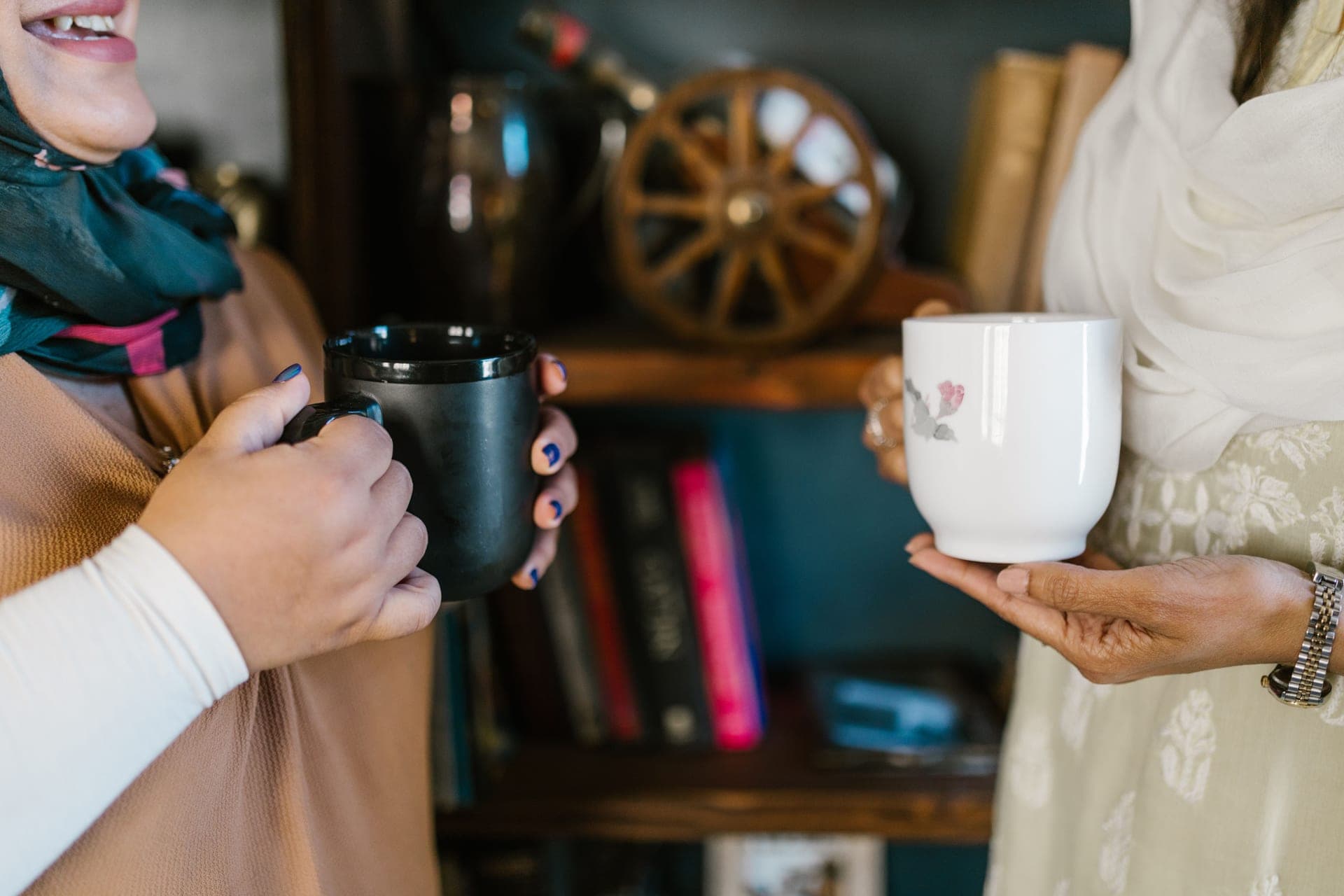 A cup of black coffee beside a cup of black tea