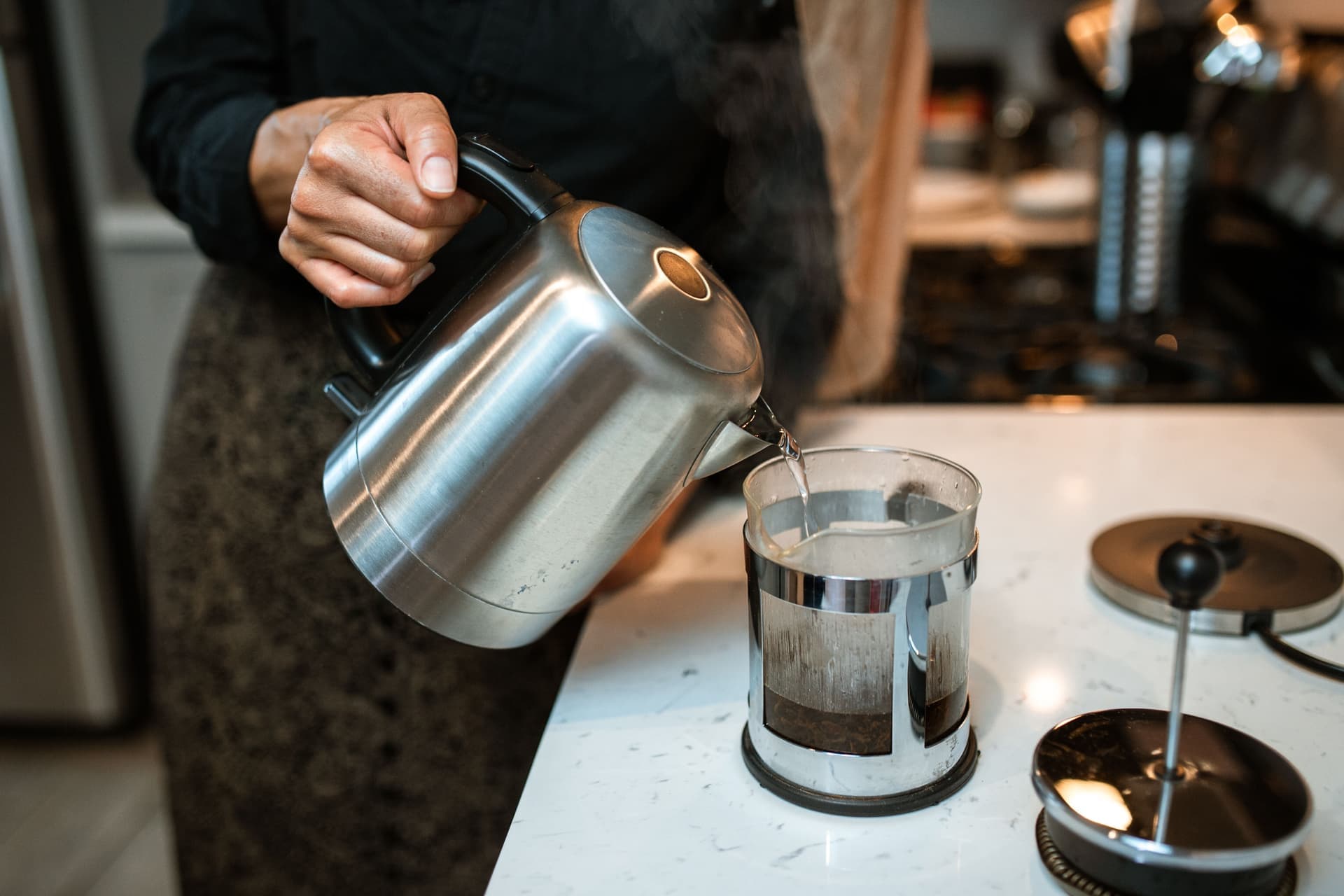 A French press on a kitchen counter in morning light