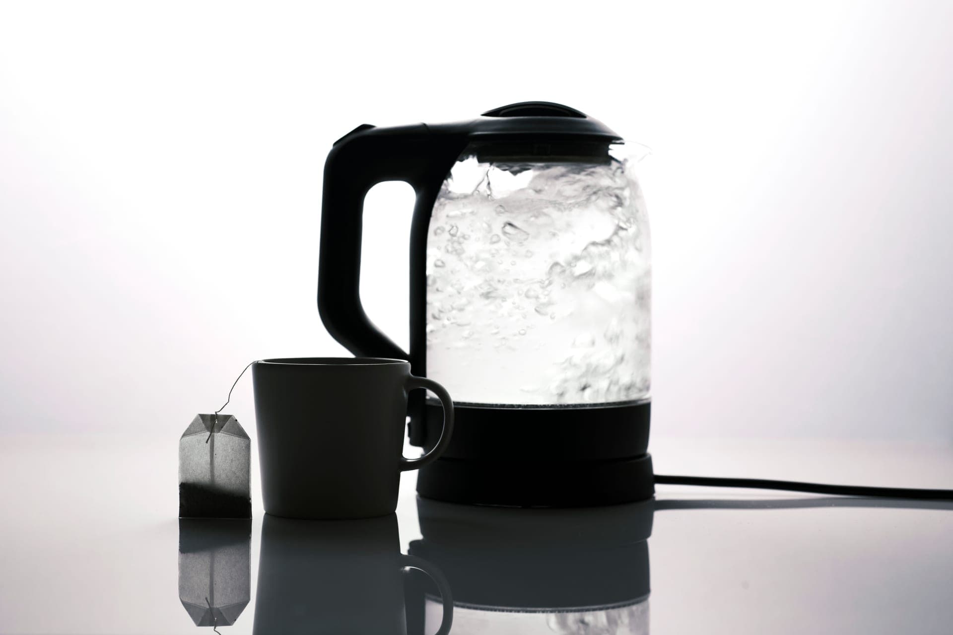 An electric kettle on a kitchen counter beside a mug