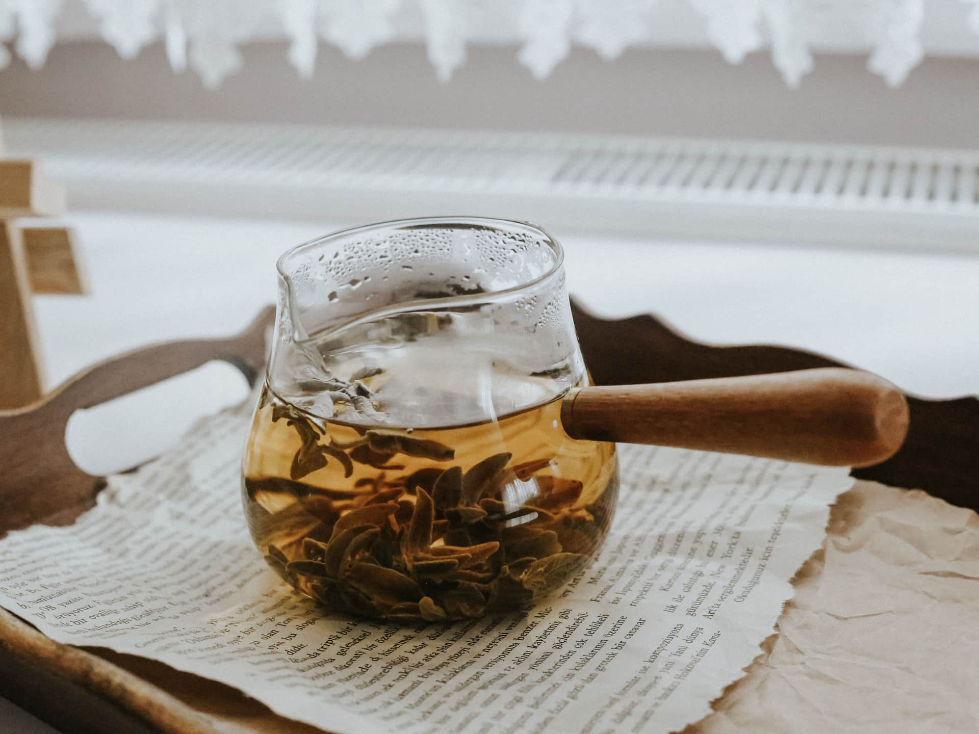 A clear glass teapot being rinsed after use